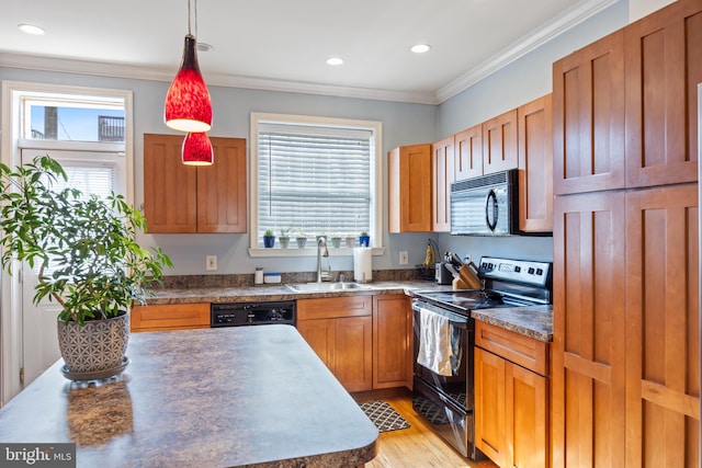 250 S Bouldin St, Baltimore, MD 21224 - kitchen with crown molding, dark countertops, a sink, black appliances, and light wood-style floors