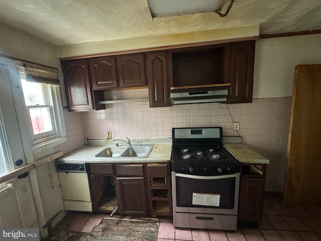kitchen featuring light countertops, under cabinet range hood, stainless steel range with gas stovetop, a sink, and dishwasher
