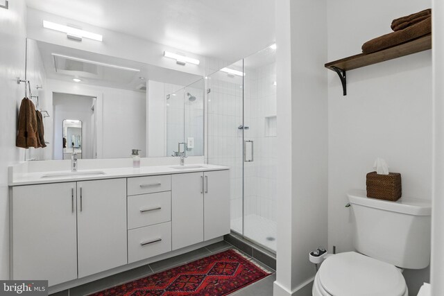 bathroom with toilet, a shower stall, tile patterned flooring, and double vanity