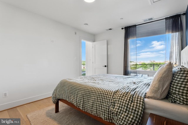bedroom with light wood-type flooring and baseboards