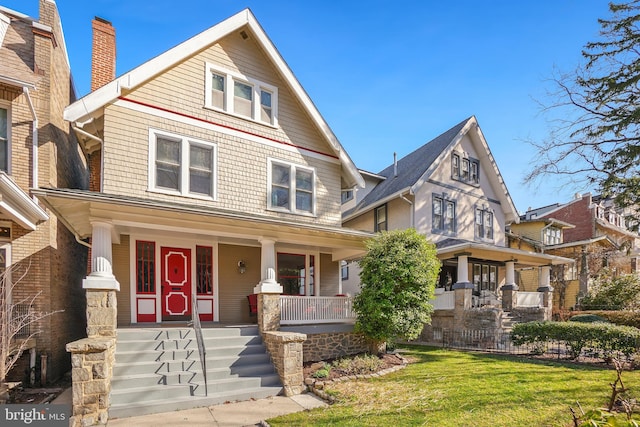 traditional style home featuring covered porch and a front yard