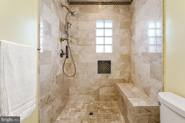 full bath with toilet and a tile shower