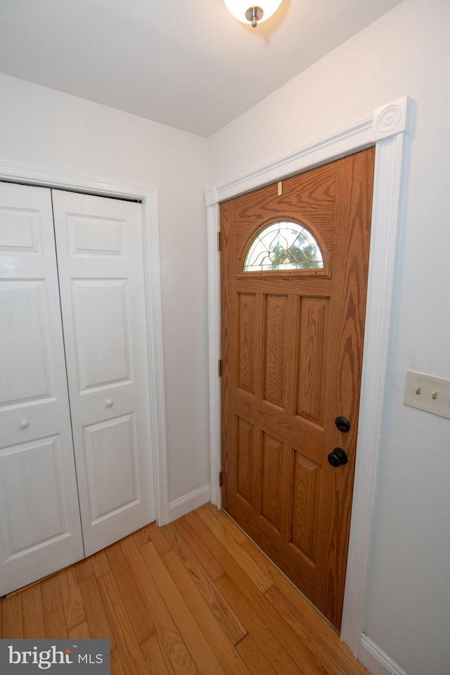 entrance foyer with baseboards and light wood-style floors