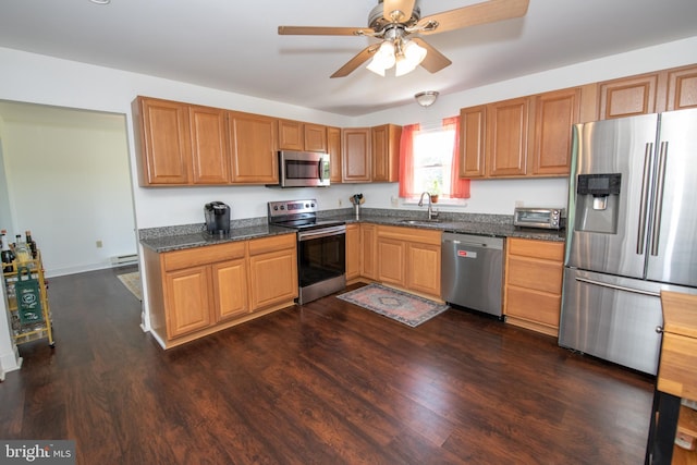 kitchen with a baseboard radiator, a ceiling fan, stainless steel appliances, and dark wood-style flooring