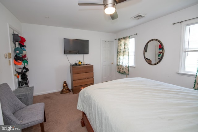 carpeted bedroom with ceiling fan, visible vents, and multiple windows