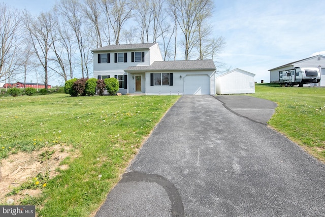 view of front of home featuring a garage, driveway, and a front yard