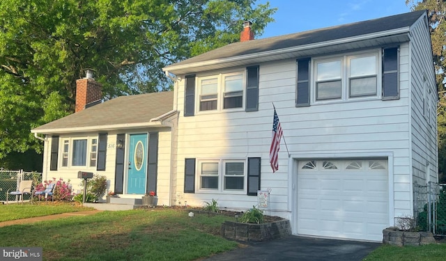 tri-level home featuring a chimney, a garage, and driveway