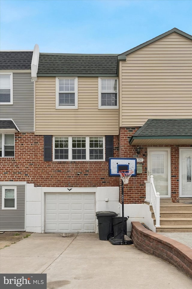 11757 Dimarco Dr, Philadelphia, PA 19154 - view of front of home featuring a garage, concrete driveway, brick siding, and a shingled roof