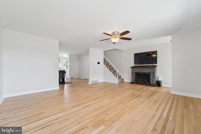 11757 Dimarco Dr, Philadelphia, PA 19154 - unfurnished living room with a stone fireplace, ceiling fan, light wood-style flooring, and baseboards