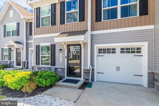 28020 Dew Drop Ln, Millville, DE 19967 - doorway to property with concrete driveway, board and batten siding, stone siding, and a garage