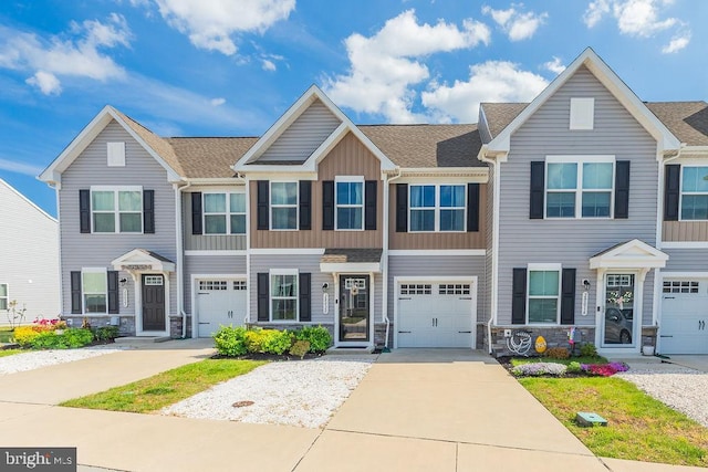 28020 Dew Drop Ln, Millville, DE 19967 - view of property featuring a shingled roof, board and batten siding, concrete driveway, and stone siding