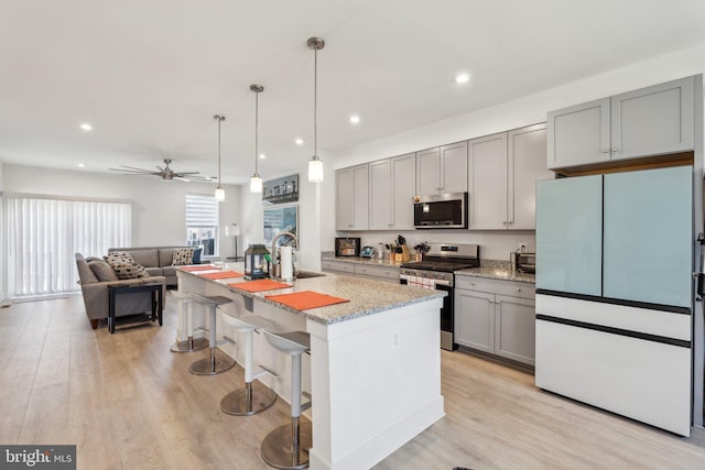 1490 Meadowlark Glen Rd, Dumfries, VA 22026 - kitchen featuring stainless steel appliances, gray cabinets, light stone counters, light wood-style floors, and recessed lighting