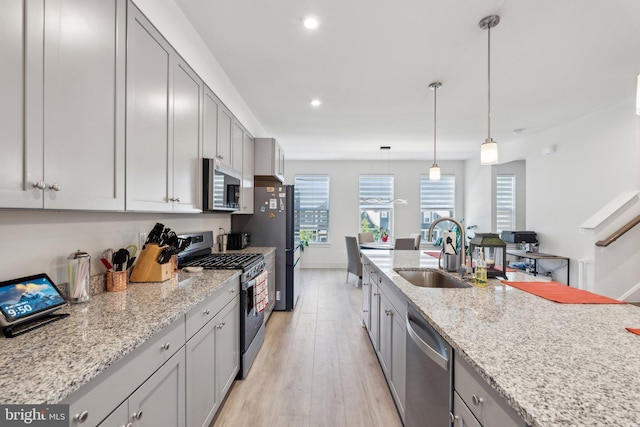 1490 Meadowlark Glen Rd, Dumfries, VA 22026 - kitchen with appliances with stainless steel finishes, a sink, light wood-style floors, recessed lighting, and light stone counters