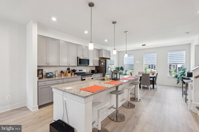 1490 Meadowlark Glen Rd, Dumfries, VA 22026 - kitchen with appliances with stainless steel finishes, gray cabinets, light wood finished floors, an island with sink, and a sink