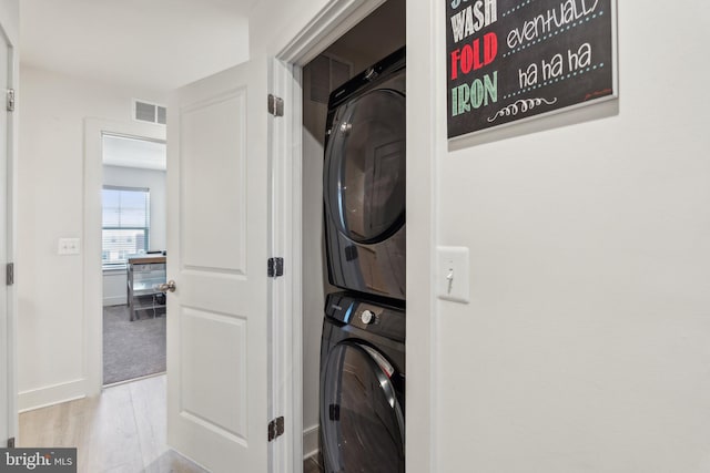 1490 Meadowlark Glen Rd, Dumfries, VA 22026 - washroom featuring stacked washer and clothes dryer, wood finished floors, and baseboards