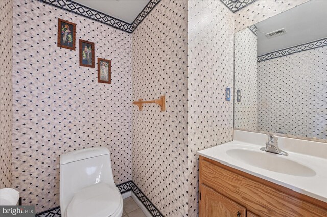 bathroom featuring visible vents, tile patterned floors, toilet, and vanity