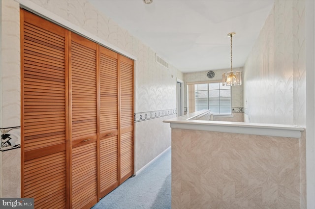 kitchen with visible vents, pendant lighting, carpet floors, a chandelier, and wallpapered walls