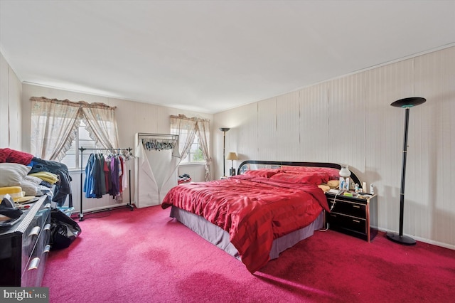 bedroom with wood walls and carpet