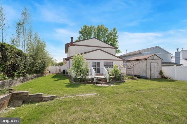 back of house featuring a storage shed, an outbuilding, a lawn, and a fenced backyard