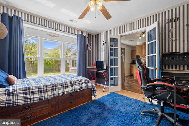 bedroom featuring wallpapered walls, visible vents, wood finished floors, and ceiling fan
