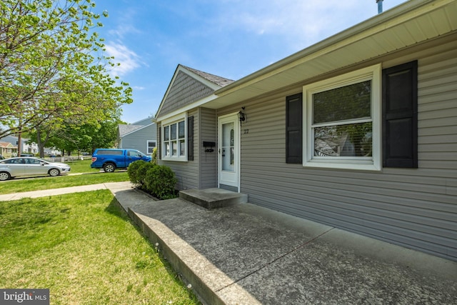 view of exterior entry with a yard