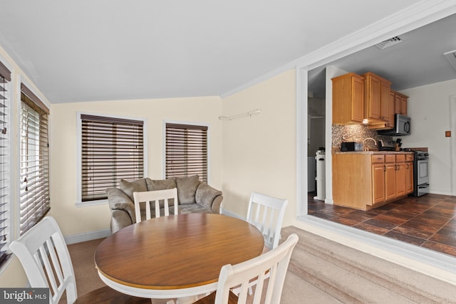 dining area with vaulted ceiling, baseboards, and visible vents