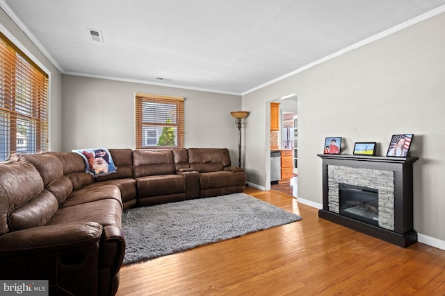 living area with light wood finished floors, crown molding, and visible vents