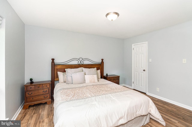 bedroom featuring baseboards and wood finished floors