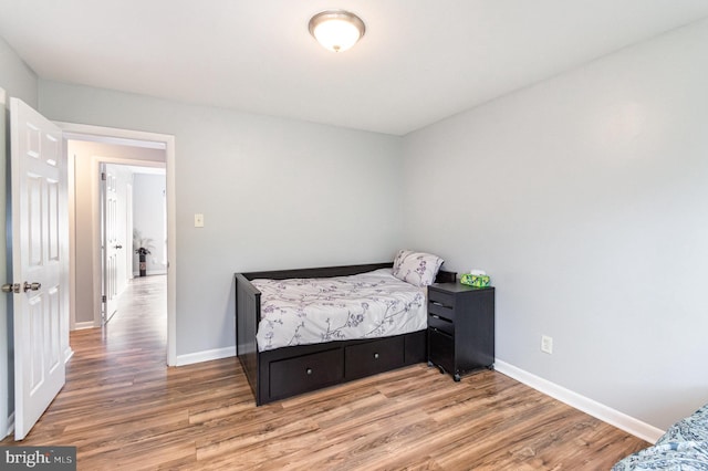 bedroom featuring baseboards and light wood-style flooring