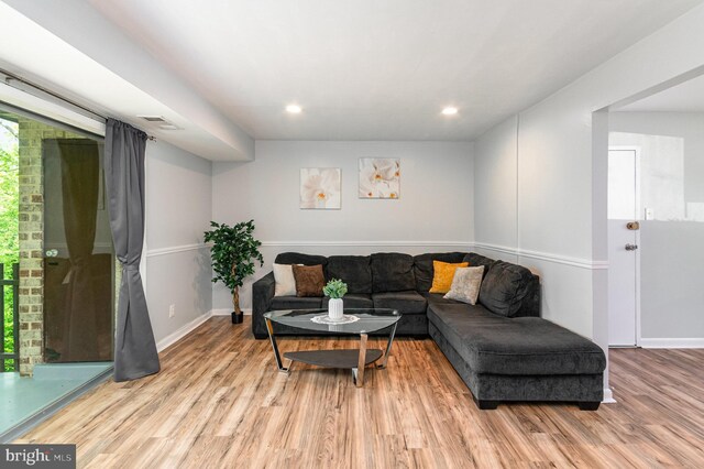 living area featuring baseboards, recessed lighting, wood finished floors, and visible vents
