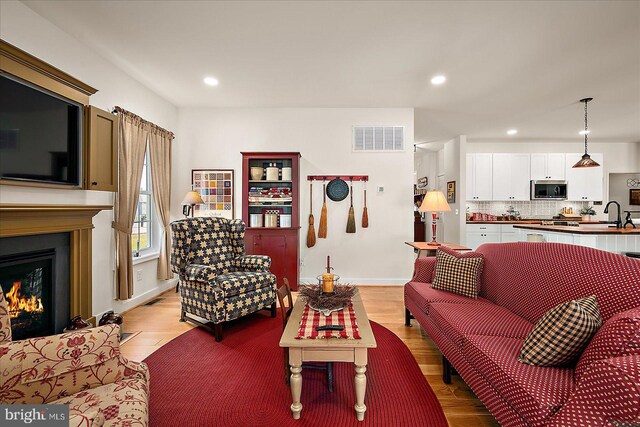 38284 Clearwater Ct, Ocean View, DE 19970 - living area featuring light wood-type flooring, a warm lit fireplace, recessed lighting, and visible vents