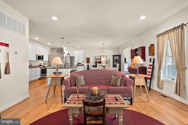 38284 Clearwater Ct, Ocean View, DE 19970 - living room with light wood-style floors, a notable chandelier, baseboards, and recessed lighting