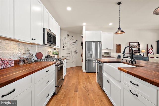 38284 Clearwater Ct, Ocean View, DE 19970 - kitchen featuring appliances with stainless steel finishes, butcher block counters, a sink, tasteful backsplash, and light wood-type flooring