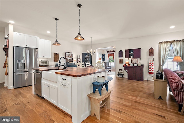 38284 Clearwater Ct, Ocean View, DE 19970 - kitchen with a notable chandelier, wooden counters, a sink, stainless steel appliances, and light wood-type flooring