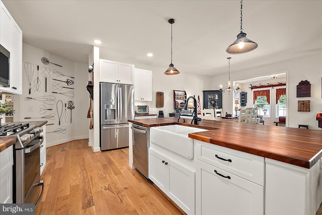 38284 Clearwater Ct, Ocean View, DE 19970 - kitchen with appliances with stainless steel finishes, butcher block counters, a sink, white cabinetry, and light wood-type flooring