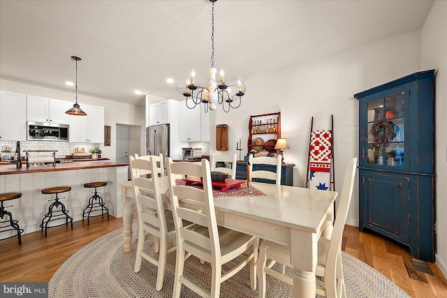38284 Clearwater Ct, Ocean View, DE 19970 - dining area featuring light wood finished floors, an inviting chandelier, and recessed lighting