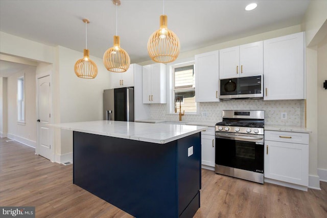 kitchen with a center island, wood finished floors, backsplash, and stainless steel appliances