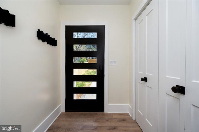 doorway to outside with baseboards and wood finished floors