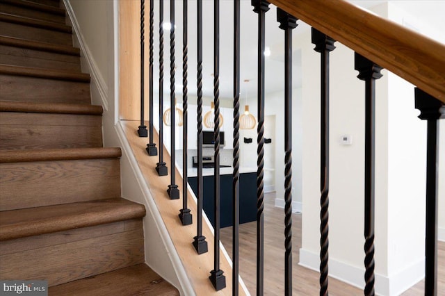 stairway with baseboards and wood finished floors