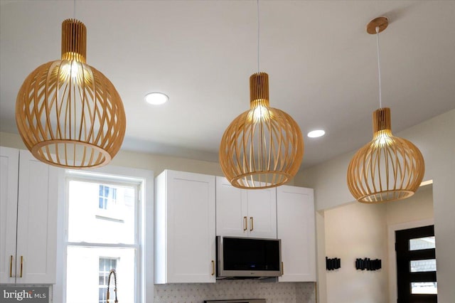room details featuring recessed lighting, decorative light fixtures, and white cabinetry