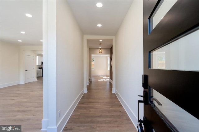 corridor with recessed lighting, baseboards, and wood finished floors