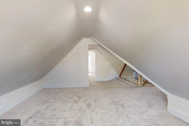 additional living space featuring carpet flooring, baseboards, and lofted ceiling