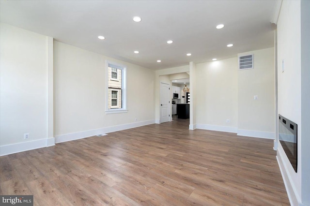 unfurnished living room featuring recessed lighting, baseboards, visible vents, and light wood-style floors