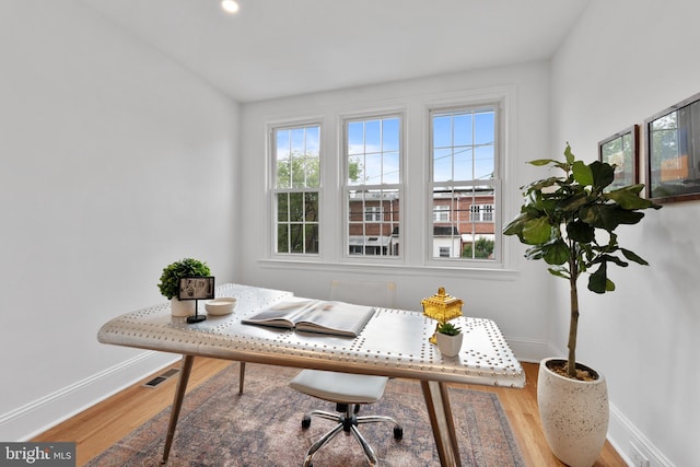 office with baseboards, wood finished floors, and visible vents