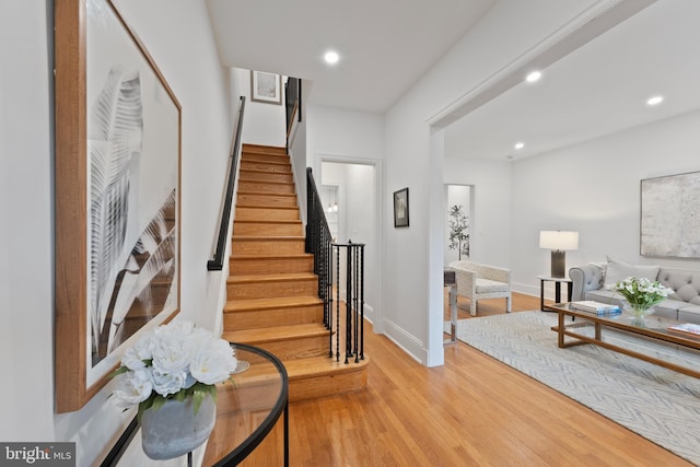 stairway with baseboards, recessed lighting, and wood finished floors