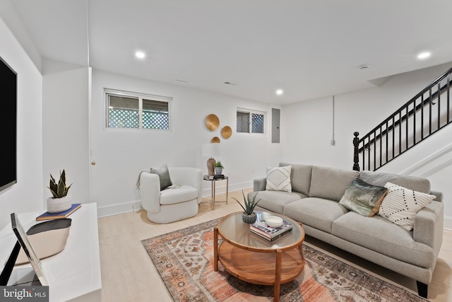 living room featuring baseboards, recessed lighting, stairs, and wood finished floors