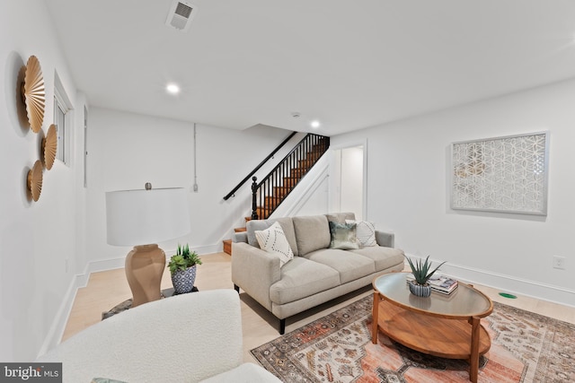 living area featuring recessed lighting, baseboards, visible vents, and stairway