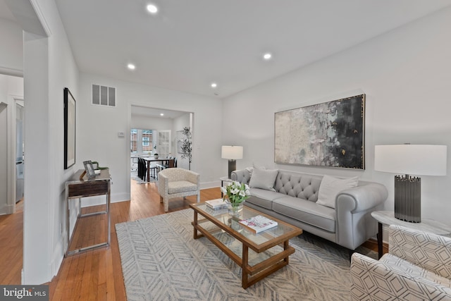 living room featuring recessed lighting, baseboards, light wood-type flooring, and visible vents