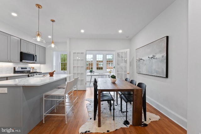 dining space featuring recessed lighting, baseboards, and light wood-type flooring