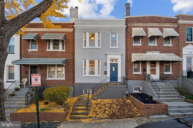view of property featuring brick siding and a chimney